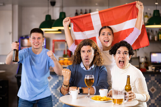 Joyful fans of the Denmark team celebrating the victory in the night bar