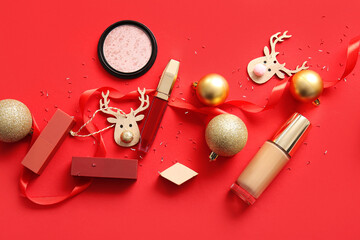 Composition with decorative cosmetics and Christmas decor on red background