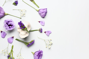 Composition with human skull and beautiful flowers on white background