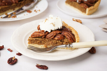 Plate with piece of tasty pecan pie on white background
