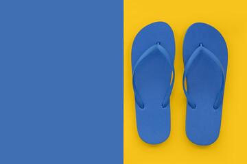 Pair of blue flip flops on colorful background