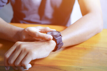Close up shot of a man checking time on her watch
