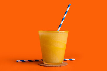 Glass of tasty melon smoothie on orange background