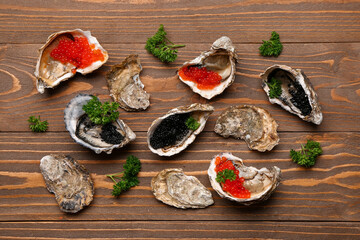 Tasty oysters with black and red caviar on wooden background