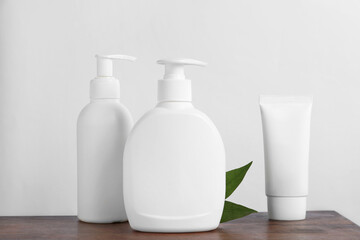 Bottles with different cosmetic products on wooden table