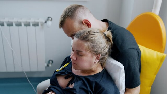 Husband is holding his pregnant wife in arms. Woman feeling pain from the contractions. Close up.