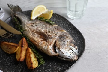 Delicious baked fish served on grey table, closeup. Seafood