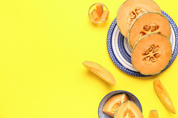 Plate and bowl with pieces of sweet melon on yellow background