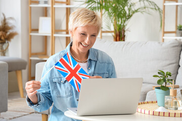 Mature woman with UK flag learning English language online at home