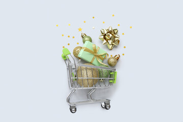 Small shopping cart with Christmas decor on white background