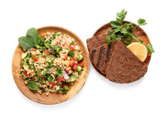 Plate with delicious tabbouleh salad and bread pieces on white background