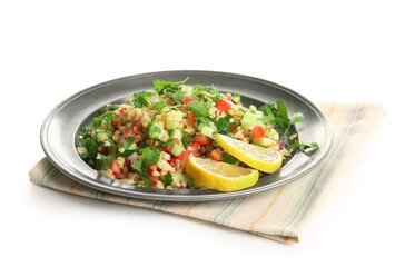 Plate with delicious tabbouleh salad and lemon slices on white background