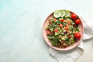 Plate with delicious tabbouleh salad on light background