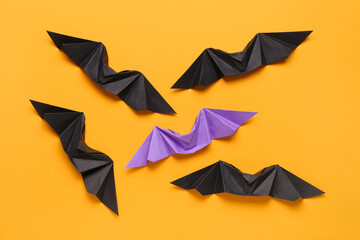Different origami bats on orange background