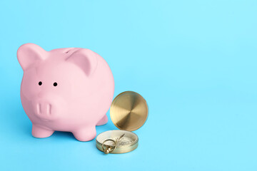 Piggy bank with compass on blue background