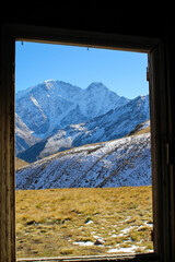Vertical image of the mountain view from the window of the old wooden barn