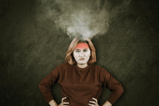 Angry Asian woman with smoking head looking at camera