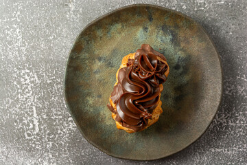 bomba de chocolate or eclair is a brazilian bakery shop sweet food dessert, over marble table