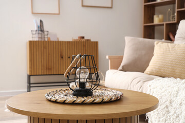 Stylish lamp on coffee table in living room, closeup