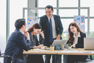 Asian professional successful businessman manager entrepreneur in formal suit standing teaching brainstorming marketing strategy with male female businesswomen employees team in company meeting room