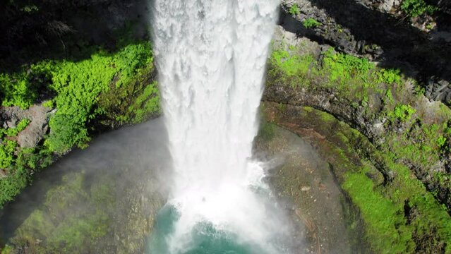 Drone Following Water Cascading Off Breathtaking Waterfall