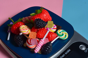 Digital scales that are weighing chocolate, strawberries and several items. Kitchen scale for...