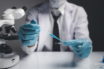 Lab assistant, a medical scientist, a chemistry researcher holds a glass tube through the blood sample, does a chemical experiment and examines a patient's blood sample. Medicine and research concept.