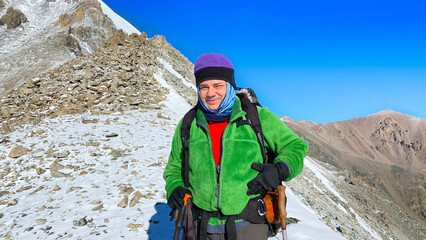 Happy smiling man climber in the mountains. Ala-Archa National Park, Kyrgyzstan. Active holidays in Asia. A beautiful landscape