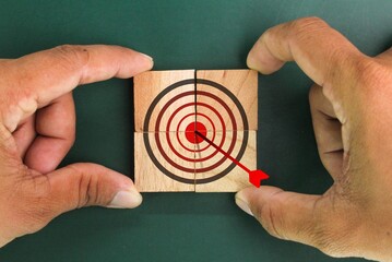hand holding wooden square with target icon. business growth process, technology trend, economic...