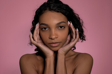 Studio shot with black woman on pink background.Skincare,wellness,wellbeing and beauty concept. 