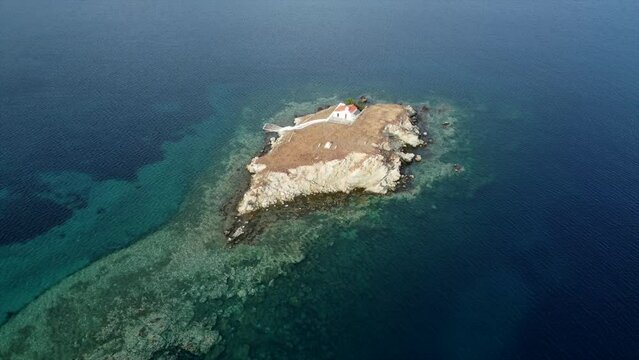 Small uninhabited island with a church aerial cinematic drone footage Greece

