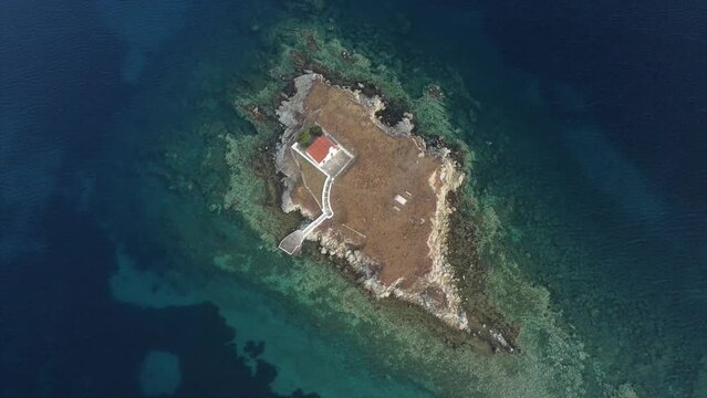 Small uninhabited island with a church aerial cinematic drone footage Greece
