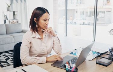 Web designer, laptop and serious business woman reading project proposal online in a office. Report, female professional and thinking on a computer with typing and tech research for website analysis
