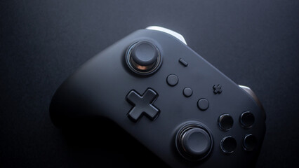 A black console game controller isolated with black background. © Soginoto