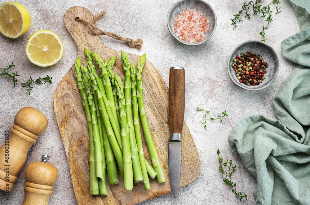 Wall mural bunch of raw asparagus stems with different spices