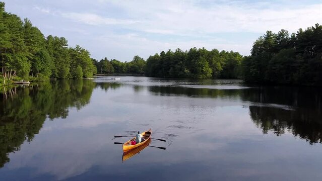 Aerial Backward Shot Of Man Boating In Tranquil River Against Sky - Boston, Massachusetts