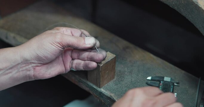 jeweler makes silver wire measurements using caliper in preparation for the production of jewelry or a ring