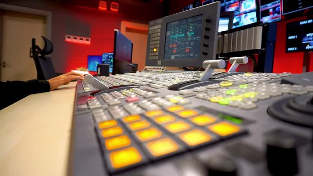 A Director in Tv Control Room. Video Switcher Using Video Mixer in Broadcasting TV Studio - Close-up of Hand. Switching and pushing buttons. Live Production Equipments.
