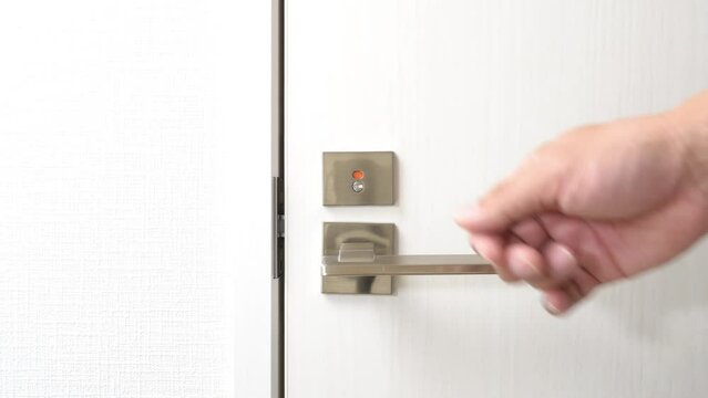 トイレのドアをノックする男性の手元
