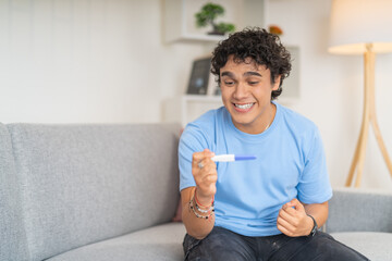 Young man celebrating the results of a pregnancy test