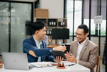 Business law concept, Lawyer business lawyers are consulting lawyers for man entrepreneurs to file copyright lawsuit with laptop and tablet at office