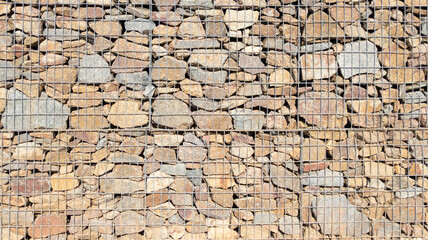 gabion steel metal stone basket background facade restored wall assembled with stones of different...
