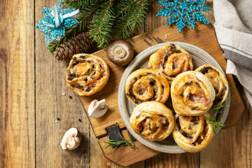 Pizza rolls puff pastry stuffed with prosciutto bacon, mushrooms and cheese on the Christmas table,...