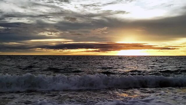 Tranquil Sunset in the Philippines During Golden Hour Ocean Waves Gracefully Rolling on the Beach, Looc Bay.