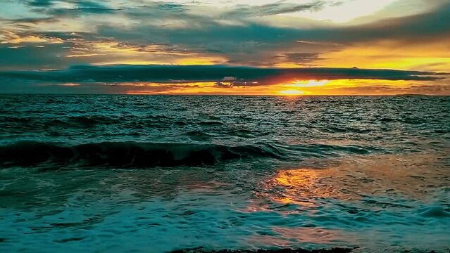Golden Hour Sunset with Tranquil Ocean Waves Gently Rolling Over Beach in Looc Bay, Philippines.