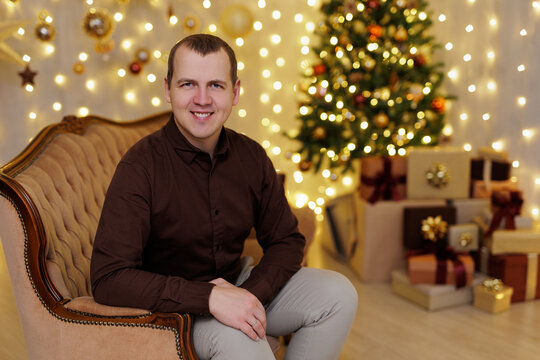 Smiling man sitting on sofa near christmas tree