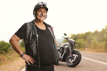 Mature biker with a leather vest and a helmet smiling