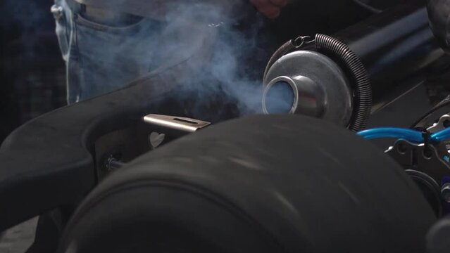 The exhaust pipe of a sport mouse releases smoke. Close-up