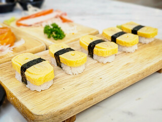 Sweet eggs sushi, Rice topped with Sweet egg sushi. Japanese sweet egg roll served on wooden dish.