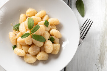 Piatto di deliziosi gnocchi di patate conditi con burro e salvia, cibo italiano 